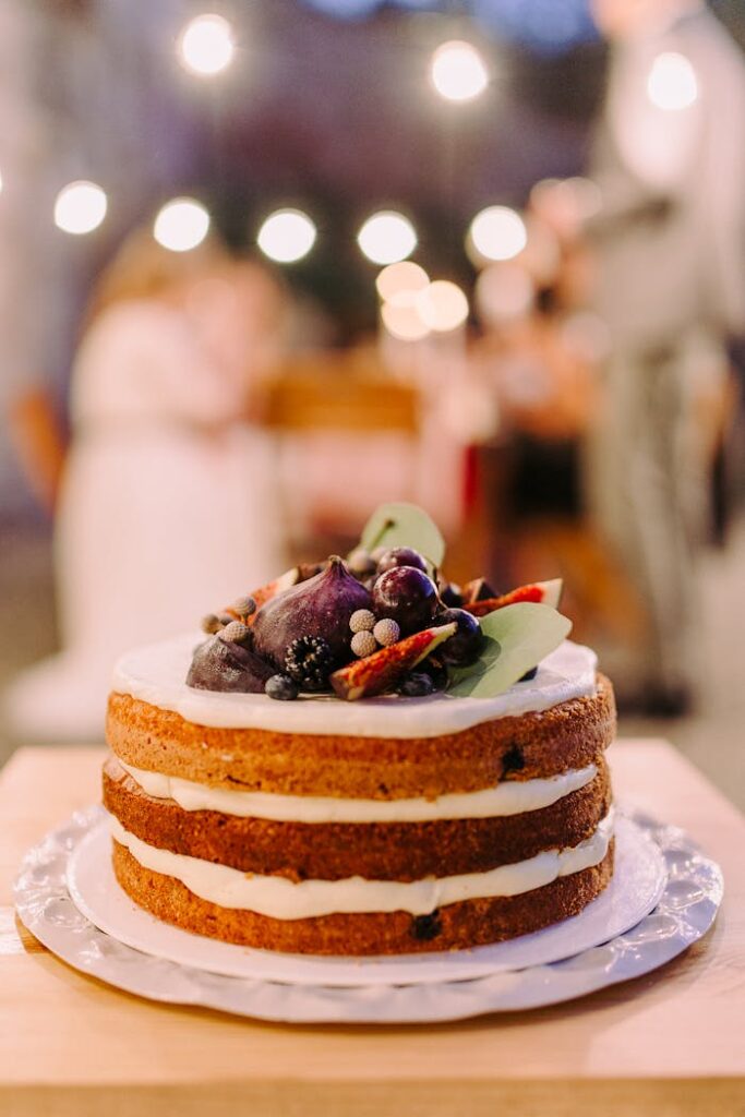 Shallow Focus of White Icing-covered Cake on White Ceramic Plate